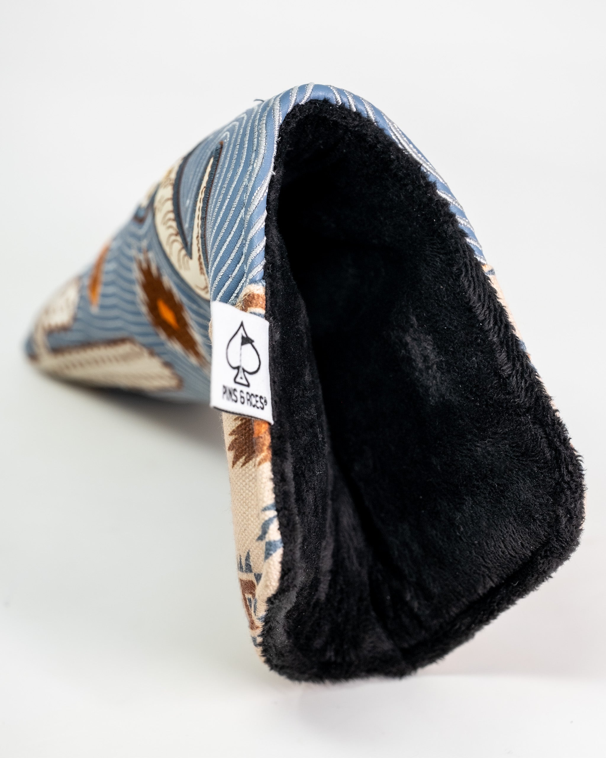 Western aesthetic blade putter cover with a floral pattern, soft black interior lining, and a brand tag on the side.