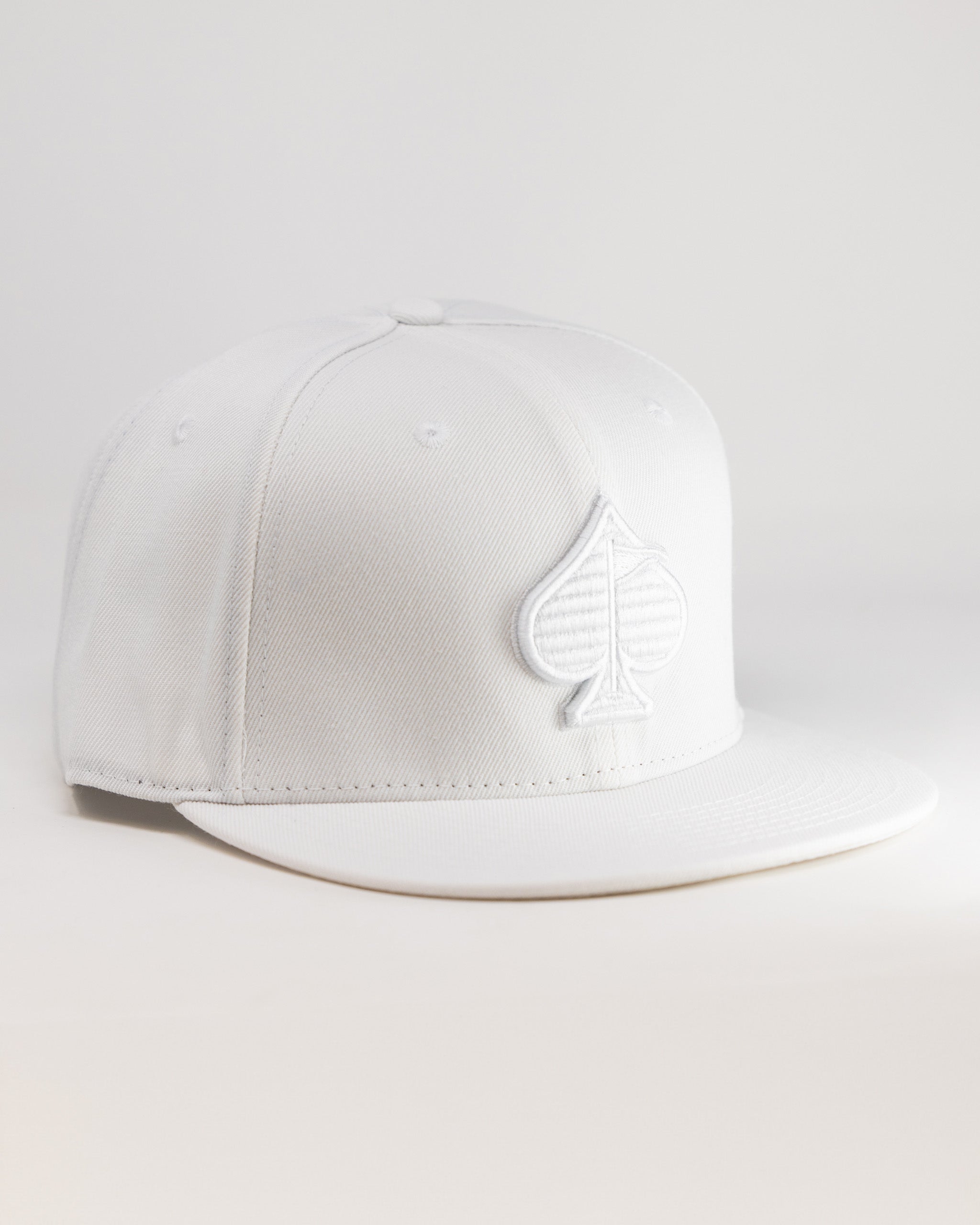 White golf cap with a raised spade logo, sleek design, perfect for bold golf apparel fans.