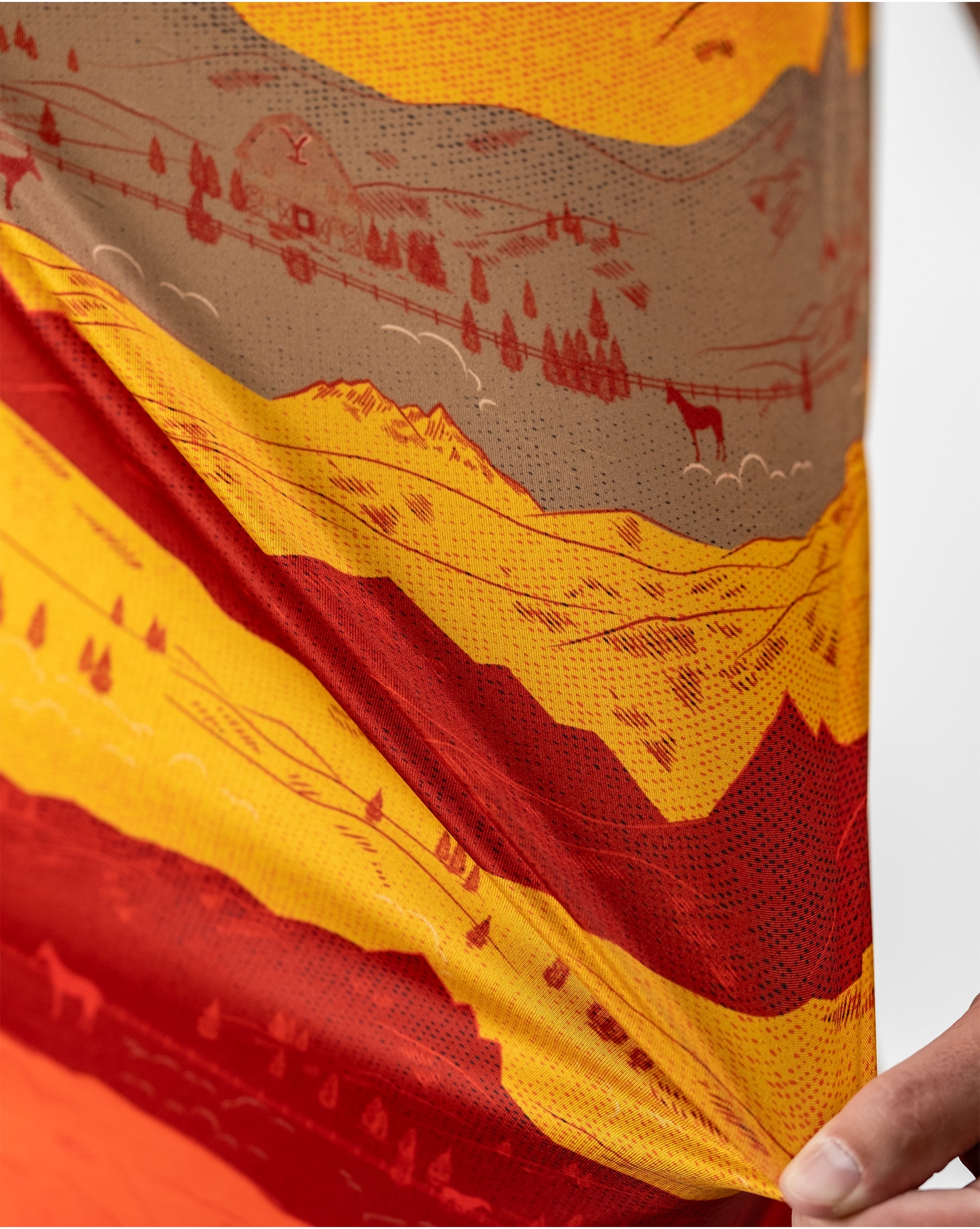 Sunset over Yellowstone National Park, showcasing vibrant orange and purple skies above silhouetted mountains and trees.